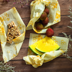 Honeycomb beeswax food wraps shown with fruit and a snack