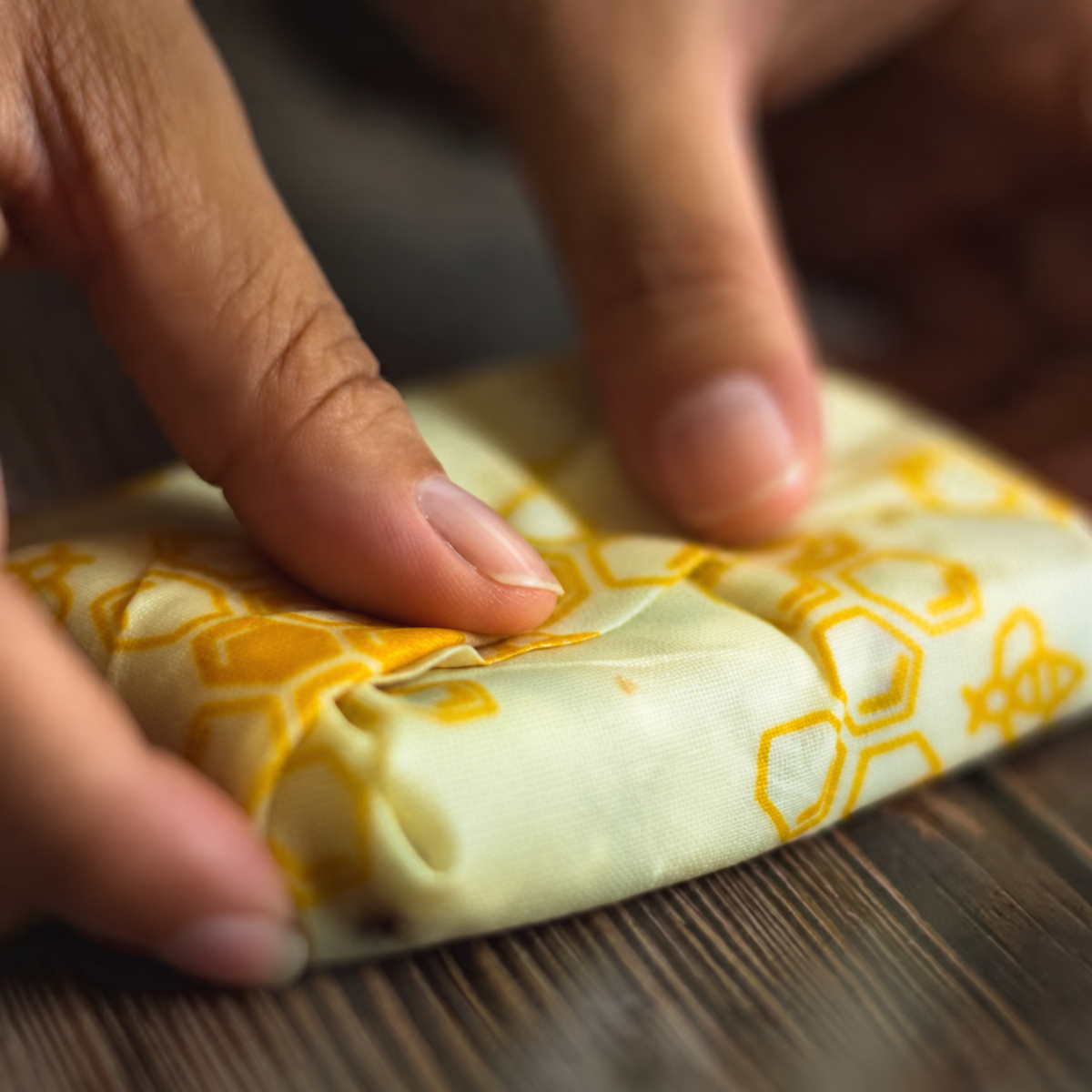 Using hand warmth to shape and press a beeswax wrap