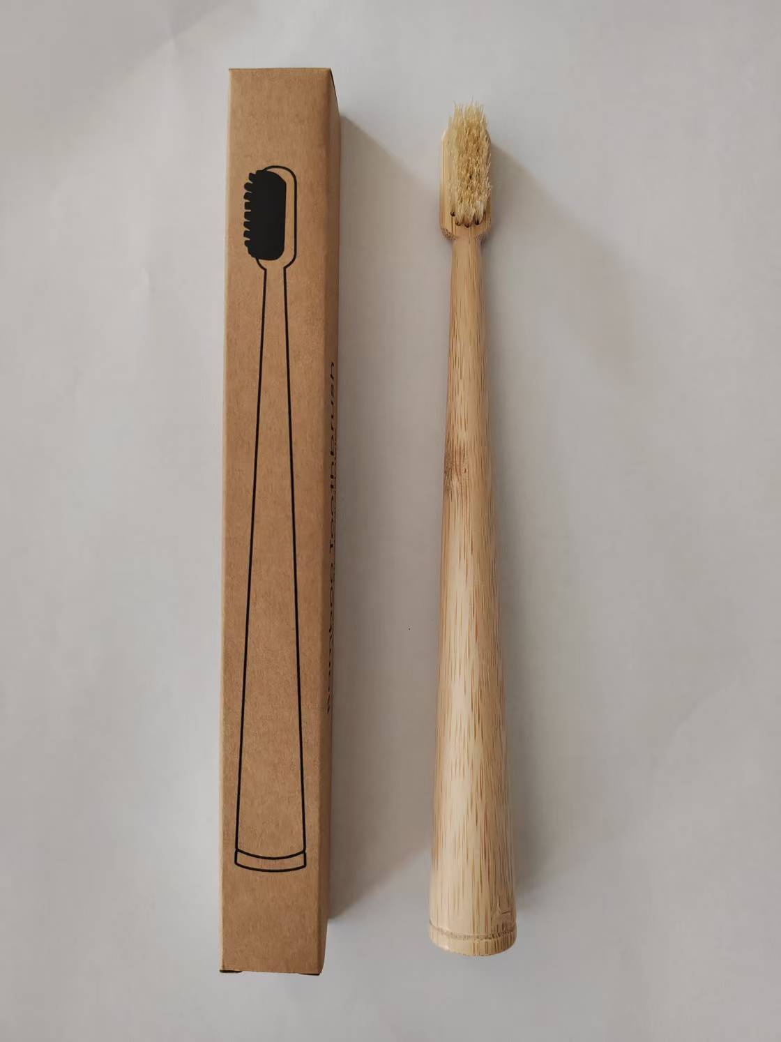 Round-handle bamboo toothbrush with light natural boar bristles, shown beside its single box