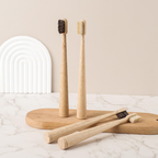 Styling photograph of bamboo toothbrushes with light boar and dark horsehair bristles; select one bristle type per pack; props not included